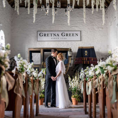 A wedding couple kissing in the Coach House wedding venue at Gretna Hall